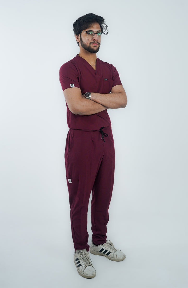 Confident doctor striking a bold pose in front view wearing maroon scrubs.