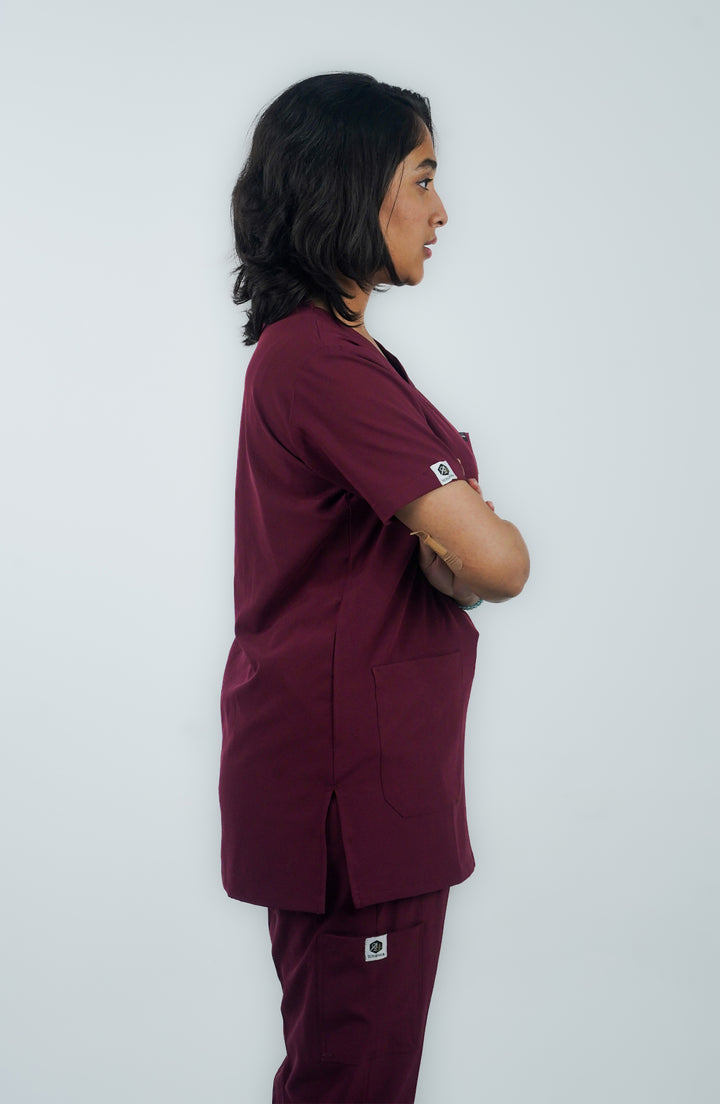 Female nurse showing side profile in ScrubyHub’s form-fitting maroon scrubs.