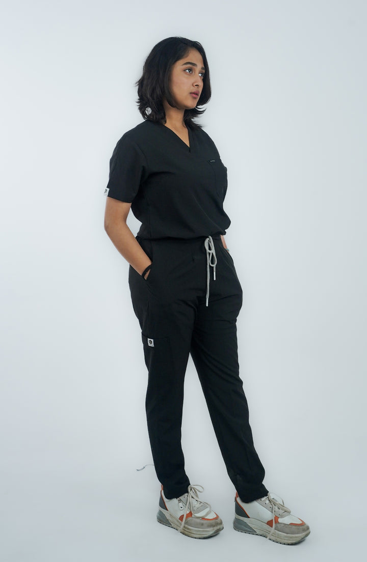 Side pose of female nurse wearing Midnight Black Charm Scrub – ScrubyHub