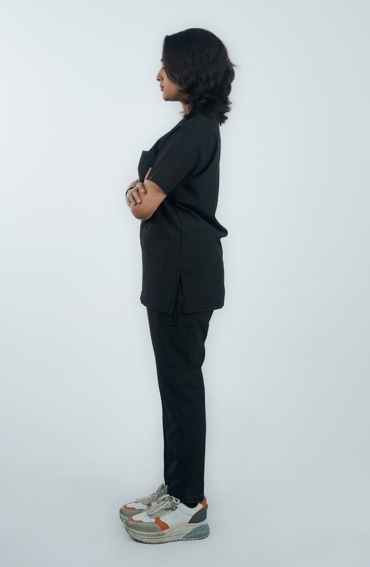 side view of lady doctor wearing midnight black scrub standing in front of white background
