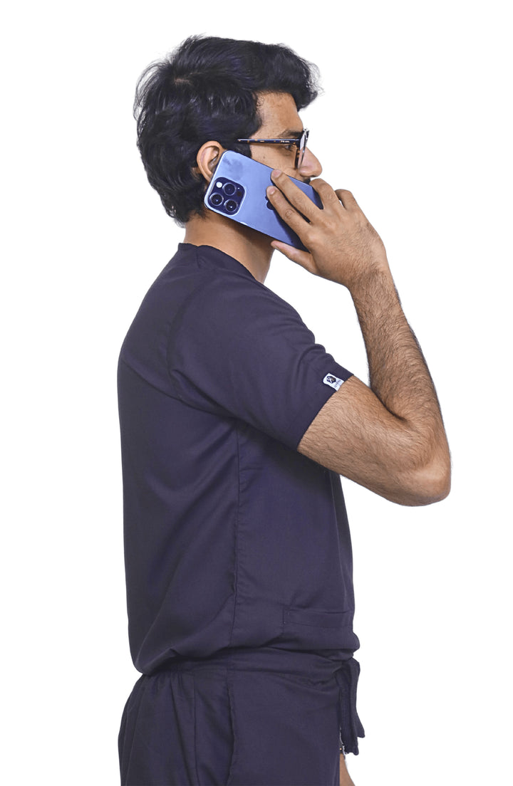 Side profile of male nurse in ScrubyHub purple scrub showcasing pocket detail.